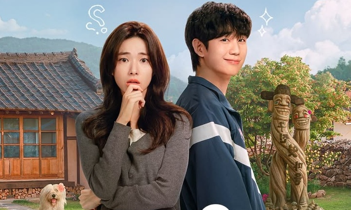 A woman with long brown hair looks concerned next to a smiling man in a blue jacket, with a traditional Korean house and wooden totems in the back.